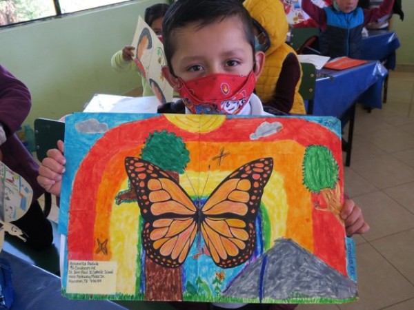 A students holds a colorful Ambassador Monarch