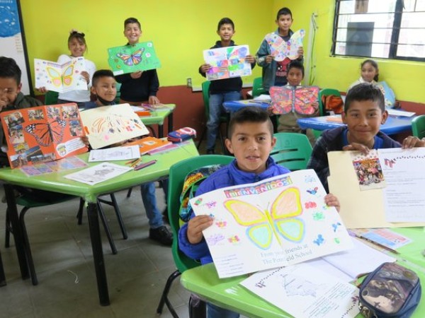 School children holding work on butterflies and moth identification