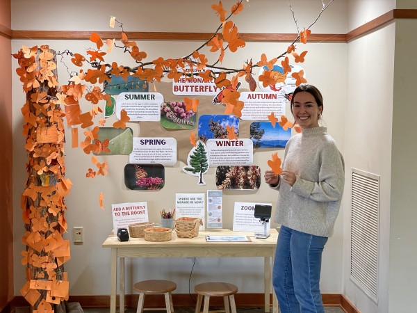 Maddie Smith in front of monarch migration exhibit