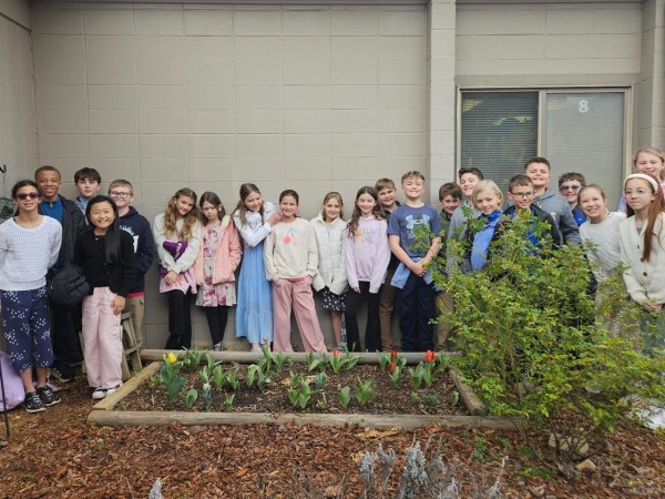 Students pose with blooming tulips